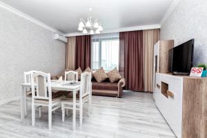 uma sala de estar com uma mesa e um sofá em Raisson Ahotel D145 em Astana