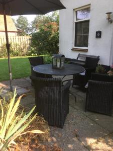 a patio table and chairs with an umbrella at Welkom op de Mildert in Nederweert