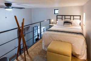 - une chambre avec un grand lit et un tabouret jaune dans l'établissement Casa Murmullos, à Guadalajara