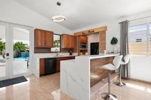 uma cozinha com armários de madeira e um balcão branco em 4 bedroom family reserve with pool home em Dorado