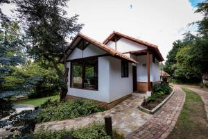 a small white house with a brick walk at Chalet Andino Sesquile in Suesca