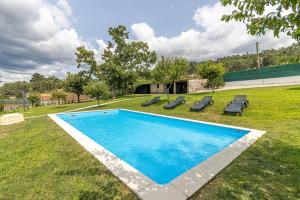 ein Schwimmbad in der Mitte eines Gartens in der Unterkunft Quinta Alvaredo in Melgaço