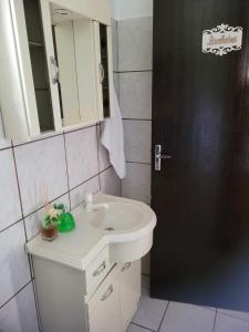 ein Badezimmer mit einem weißen Waschbecken und einem Spiegel in der Unterkunft Espaço Wunder Platz in Pomerode