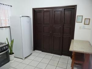 a kitchen with a brown door and a refrigerator at Espaço Wunder Platz in Pomerode