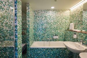 a bathroom with a tub and a sink at Scandic Berlin Potsdamer Platz in Berlin