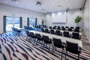 a conference room with a long table and chairs at Scandic Roskilde Park in Roskilde