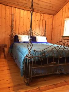 Dormitorio con cama de metal en una cabaña en Pacific Coast Hwy Bunkhouse in San Luis Obispo, en San Luis Obispo
