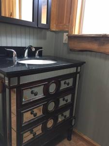 baño con lavabo y encimera negra en Pacific Coast Hwy Bunkhouse in San Luis Obispo, en San Luis Obispo