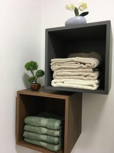 uma prateleira de madeira com toalhas num quarto em Dbo-Vivo Mall Apartment em Baia Mare