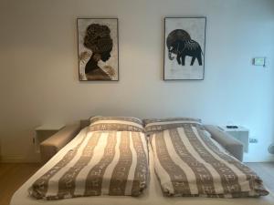 a bed in a room with three pictures on the wall at Appartamento Viola Lignano Sabbiadoro con solarium in Lignano Sabbiadoro