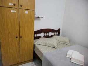 Schlafzimmer mit einem Bett und einem Holzschrank in der Unterkunft Espaço Wunder Platz in Pomerode