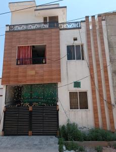 ein Gebäude mit einem Tor und einem Balkon in der Unterkunft Islamabad Comfort Home in Islamabad