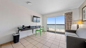 ein Wohnzimmer mit einem Tisch und einem Schreibtisch mit Aussicht in der Unterkunft SureStay Studio by Best Western Virginia Beach Oceanfront in Virginia Beach