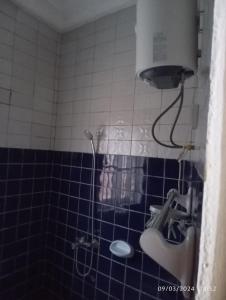 a blue tiled bathroom with a shower and a sink at Timba-Timbalog in Abomey-Calavi