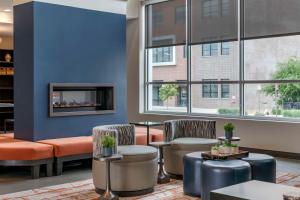 a lobby with chairs and tables and a fireplace at Vīb Hotel by Best Western Denver RiNo in Denver