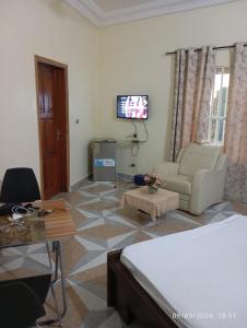 a living room with a couch and a tv at Timba-Timbalog in Abomey-Calavi