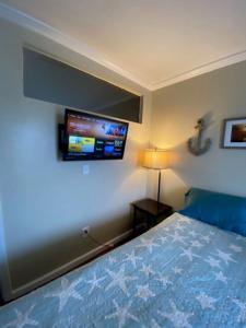 a bedroom with a bed and a tv on the wall at Beach Place Seconds to Beach 6 in Panama City Beach