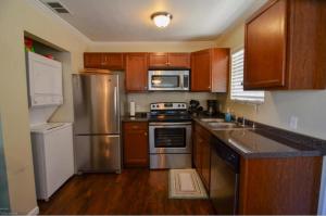 a kitchen with stainless steel appliances and wooden cabinets at Beach Place Seconds to Beach 6 in Panama City Beach
