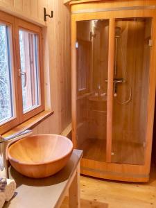 a bathroom with a wooden bowl sink and a shower at Berg-Chalet im Glamping-Paradies auf dem Dengler Hof in Hohenberg an der Eger