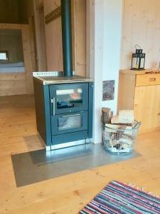 a blue stove sitting in a room with a floor at Berg-Chalet im Glamping-Paradies auf dem Dengler Hof in Hohenberg an der Eger