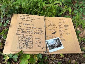 kawałek papieru z napisem na ziemi w obiekcie Cornwall Woodland Dog Friendly Shepherd's Hut w mieście Bodmin