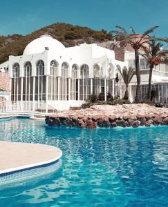 - un grand bâtiment blanc avec une piscine en face dans l'établissement CASA PERSEA, à Nerja