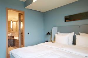 1 dormitorio con cama blanca y pared azul en Scandic Frankfurt Hafenpark, en Frankfurt