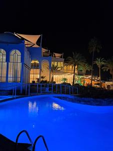 a swimming pool in front of a building at night at CASA PERSEA in Nerja