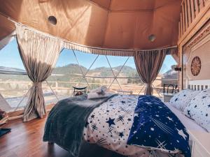 a bedroom with a bed and a large window at Cucu Zen Dome Cabana Cazare Bucovina 