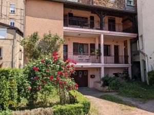 an apartment building with red flowers in front of it at Ambiance bohème in Roanne