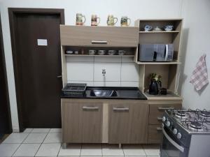 a small kitchen with a sink and a stove at Espaço Wunder Platz in Pomerode
