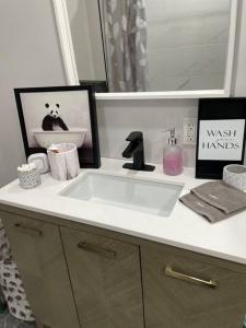 a bathroom counter with a sink and a mirror at Brand New Modern unit in town! in Cochrane