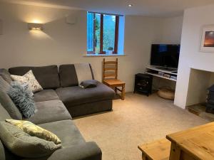 a living room with a couch and a television at Braunton Breaks - 'The Cwtch' in Braunton