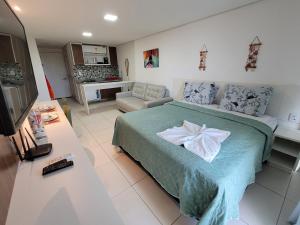 een slaapkamer met een bed en een woonkamer bij Laguna Beach Flat -205 in Porto De Galinhas