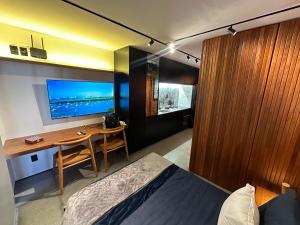 a bedroom with a bed and a desk and a television at Diamond Flat in Morro de São Paulo