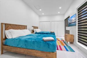 a bedroom with a large bed with a blue comforter at VillaKOBO Heated pool Spa Golf Tennis crocodile in Miami +60 photos