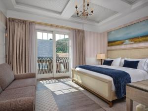 a bedroom with a bed and a couch and a window at The Northport Hotel in Northport