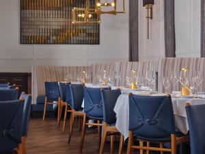 a row of tables with blue chairs and wine glasses at The Northport Hotel in Northport +13 photos