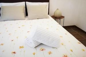 ein Bett mit einer weißen Bettdecke mit Blumen darauf in der Unterkunft Sobreiro's Villa in Douro Valley in Mesão Frio