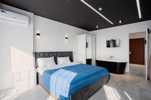 a bedroom with a large bed and a bath tub at Apartments Beach Tower in Batumi