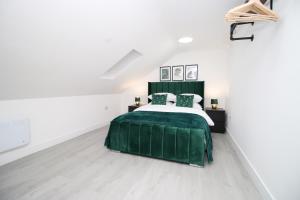 a bedroom with a green bed and white walls at New Cardiff Bloc Exclusive Apartments By Prime Stays - Shops and Parking - Great for Groups and Families in Cardiff