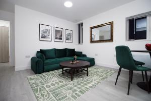 a living room with a green couch and a table at New Cardiff Bloc Exclusive Apartments By Prime Stays - Shops and Parking - Great for Groups and Families in Cardiff