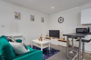 - un salon avec un canapé vert et une table dans l'établissement NEW! Perfect for Families & Corporates - 3 Beds - Contact us for Better Offers!, à Leeds