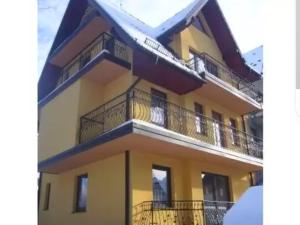 a building with balconies and snow on the ground at Willa u Samków in Zakopane