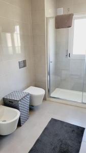 a bathroom with a toilet and a sink and a shower at Jackie Apartment in Nazaré