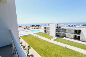 an image of a building with a swimming pool and the ocean at Jackie Apartment in Nazaré