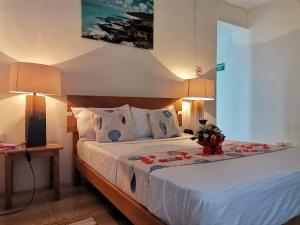 una camera da letto con un letto decorato con fiori di OR Saison a Rodrigues Island