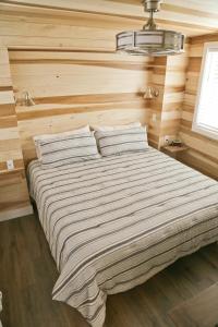 - un grand lit dans une chambre dotée de murs en bois dans l'établissement Escalante Escapes Holly Hock- King Escape, à Escalante