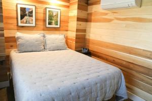 Escalante Escapes Desert Willow- Loft Escape في إيسكالانتي: غرفة نوم بسرير في غرفة بجدران خشبية