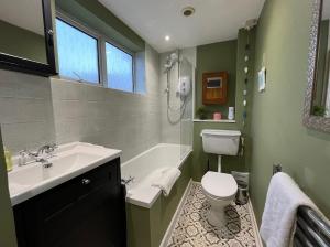 La salle de bains est pourvue d'un lavabo, de toilettes et d'une baignoire. dans l'établissement ⭐️Sleeps 4/Longstays/Garden/Parking/WiFi⭐️, à Crawley
